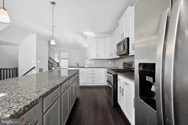 a kitchen with stainless steel appliances granite countertop a sink a stove and a refrigerator