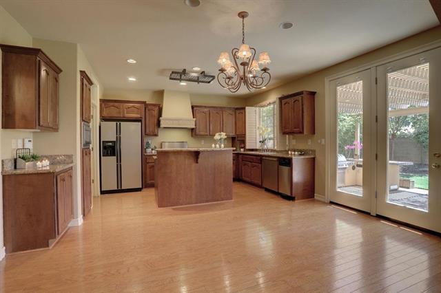 8916 Visage Circle Fair Oaks, CA 95628 - Photo 9 of 15 a open kitchen with stainless steel appliances granite countertop a refrigerator a oven a sink and a island with large windows