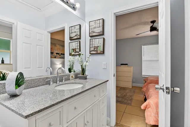a bathroom with a granite countertop sink and a mirror