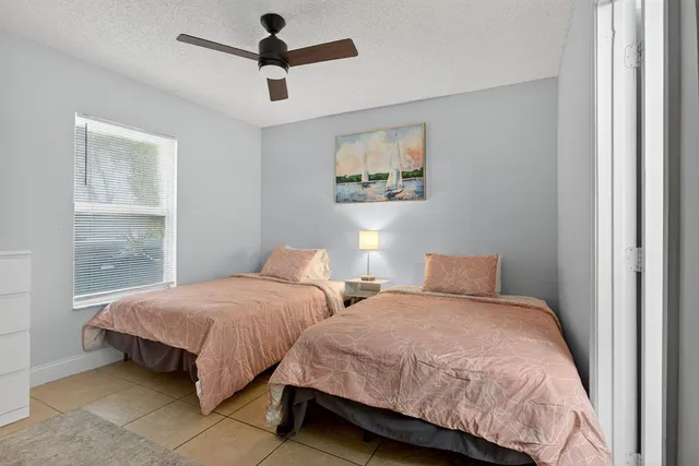 a bedroom with two beds and ceiling fan