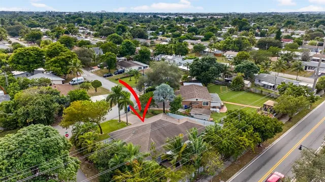 an aerial view of residential houses with outdoor space and trees