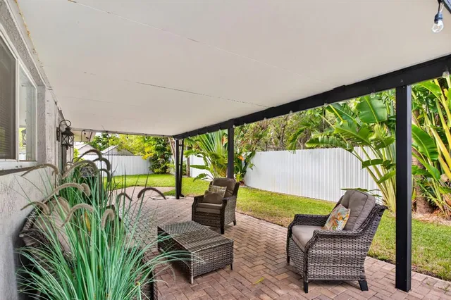 a living room with patio furniture and a floor to ceiling window