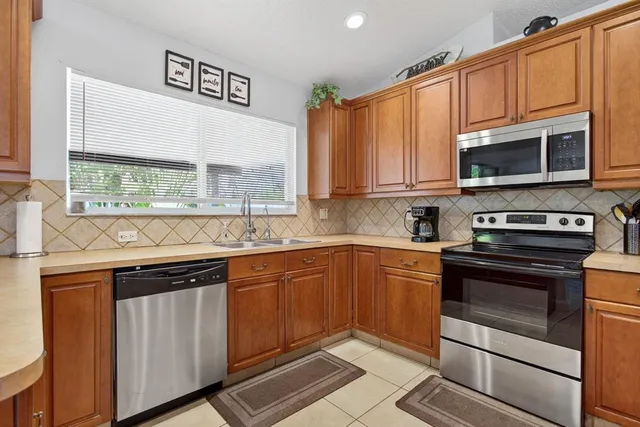 a kitchen with stainless steel appliances wooden cabinets and a stove top oven