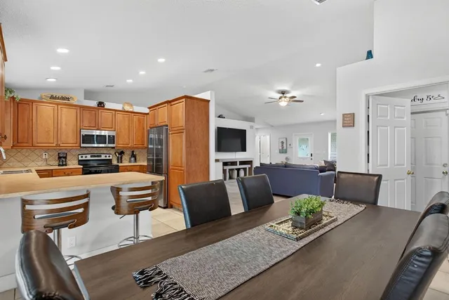a living room with stainless steel appliances furniture and a view of kitchen