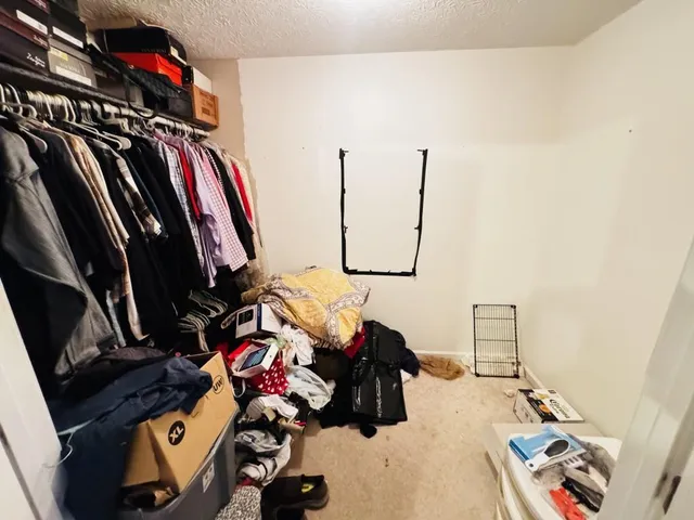 a view of walk in closet with clothes and shoes
