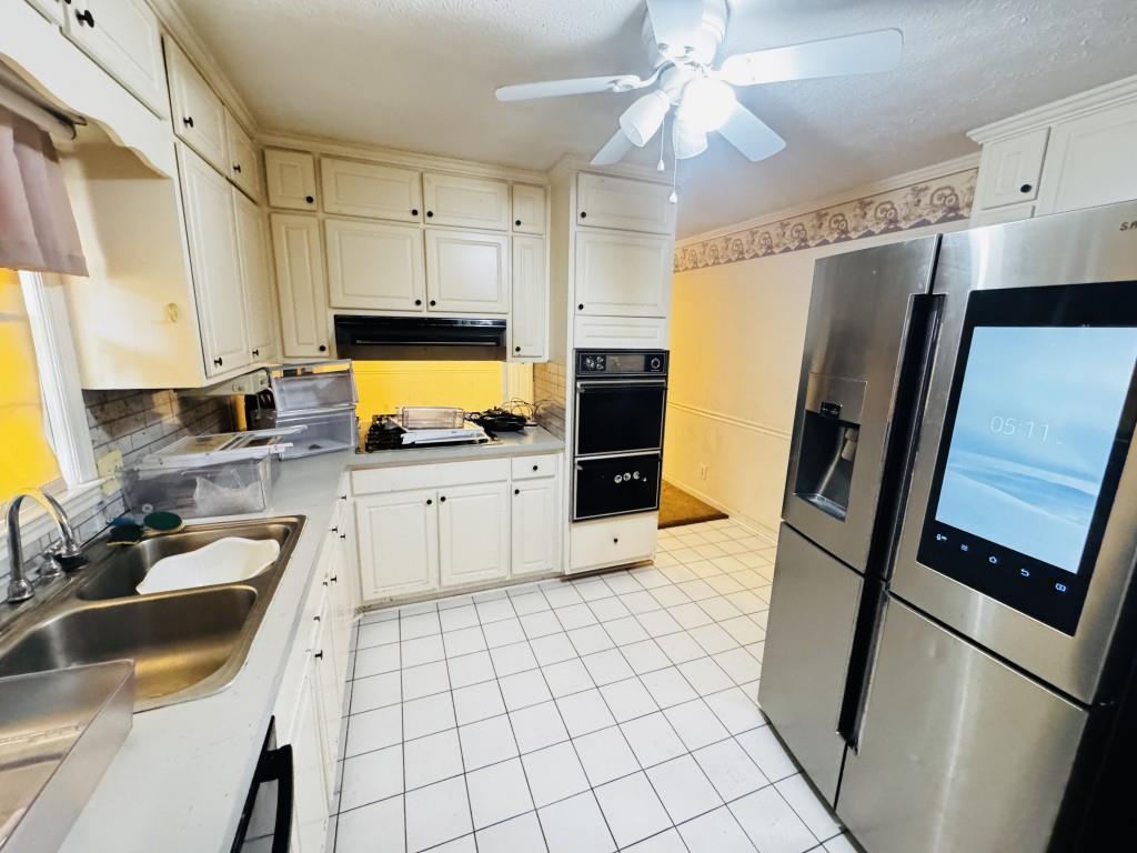 2359 Valley Way Snellville, GA 30078 - Photo 6 of 26 a kitchen with granite countertop a refrigerator a sink a stove and white cabinets