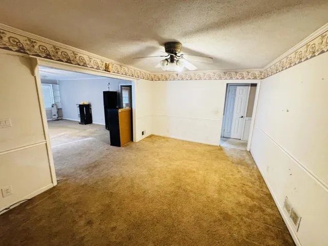 a view of a livingroom with wooden floor and a ceiling fan