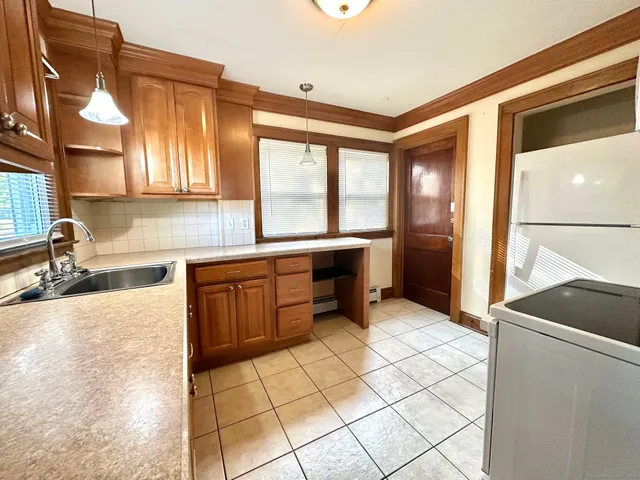 a kitchen with a sink a counter top space cabinets and stainless steel appliances