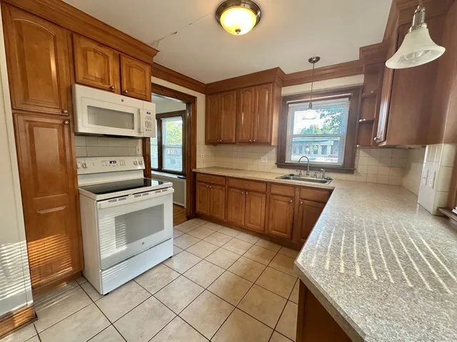 a kitchen with granite countertop a sink stainless steel appliances and cabinets