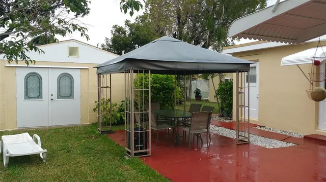 a view of a patio with table and chairs under an umbrella