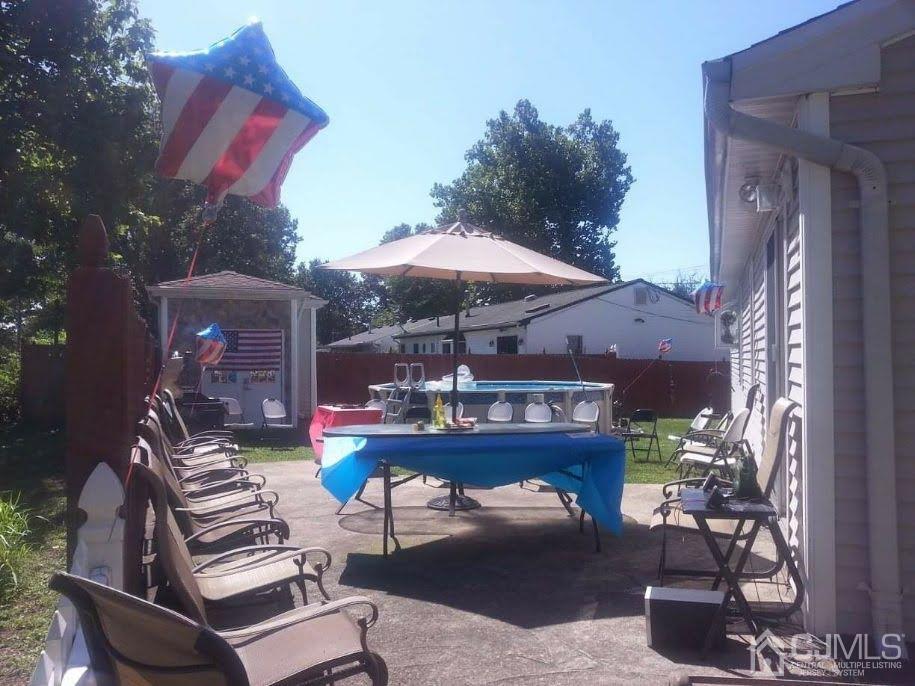 43 Princeton Road Old Bridge, NJ 08859 - Photo 25 of 26 a view of a patio with couches table and chairs under an umbrella
