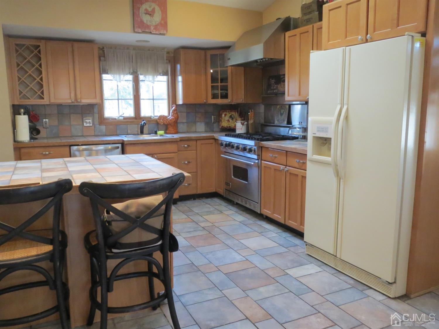 43 Princeton Road Old Bridge, NJ 08859 - Photo 6 of 26 a kitchen with stainless steel appliances granite countertop a refrigerator a sink a stove a dining table and chairs