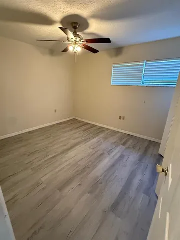 a view of a kitchen with wooden floor and electronic appliances