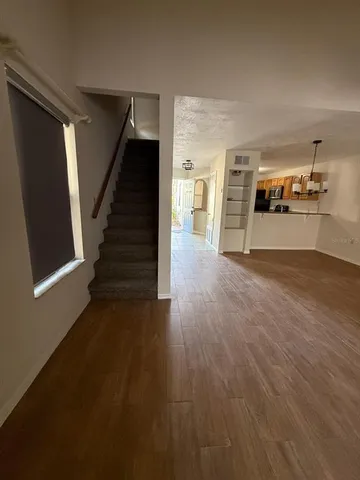 a view of a livingroom with wooden floor and stairs