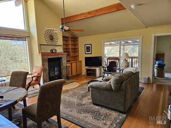 a living room with furniture a large window and a fireplace