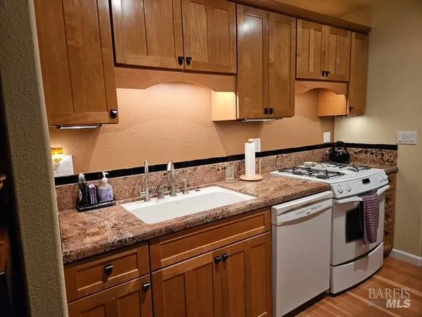 a kitchen with granite countertop stainless steel appliances a stove sink and cabinets