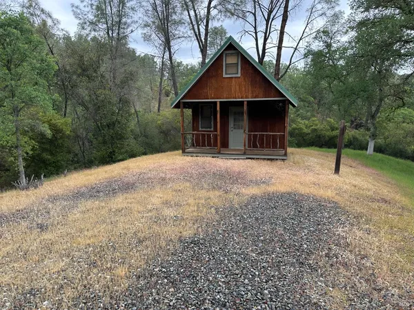 a front view of a house with a yard and trees
