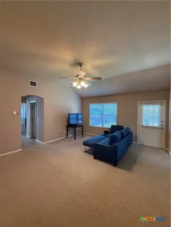 a living room with furniture a piano and a window