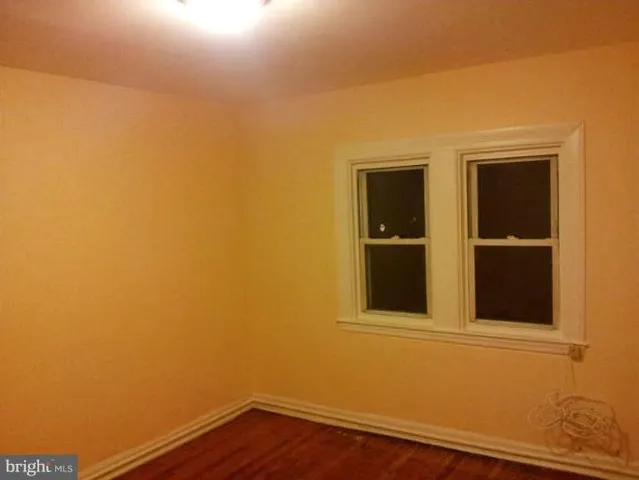 a view of a small space with wooden floor and a window
