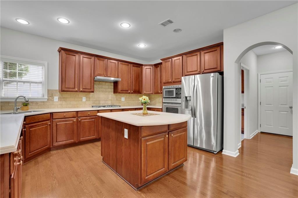 2945 Links View Way Cumming, GA 30041 - Photo 14 of 25 a kitchen with stainless steel appliances granite countertop a refrigerator a sink dishwasher and a stove with wooden floor