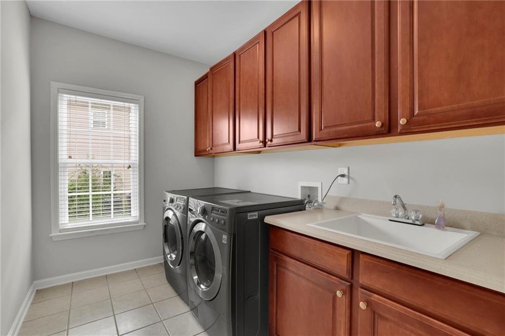 2945 Links View Way Cumming, GA 30041 - Photo 15 of 25 a utility room with a sink a washer and dryer