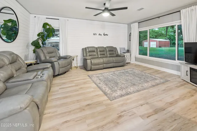 a living room with a bed furniture and a large window