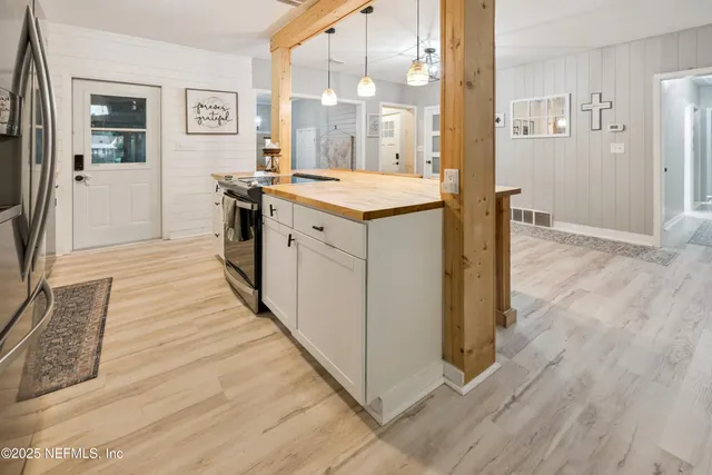a view of kitchen with stainless steel appliances granite countertop a stove top oven a sink and a refrigerator