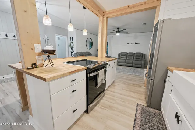 a kitchen with kitchen island a counter top space a sink appliances and cabinets