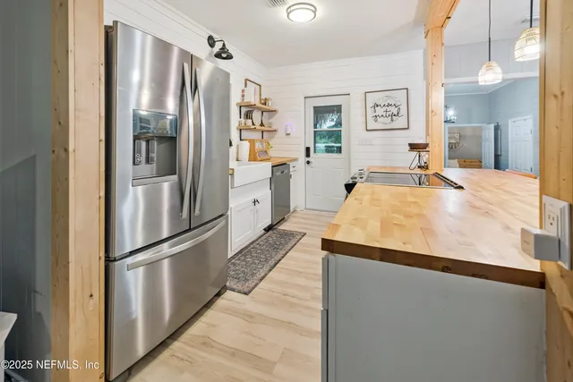 a room with stainless steel appliances a refrigerator and cabinets