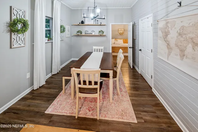 a view of a hallway with wooden floor and a bathroom