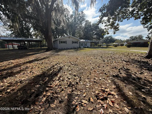 a view of a room with a large window and wooden floor