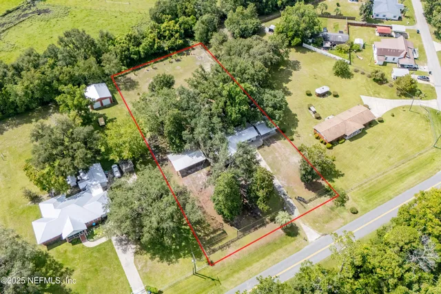 an aerial view of a house with a yard and lake
