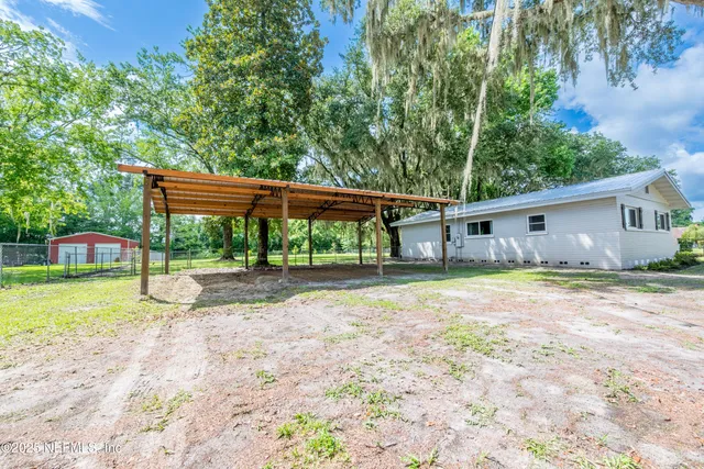 a view of a house with backyard and sitting area