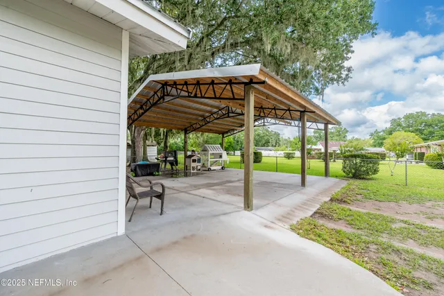 a view of a house with backyard and sitting area