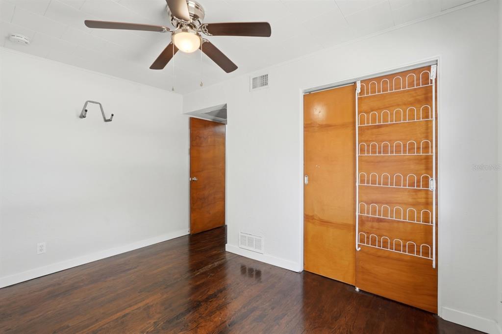 231 North Ridgewood Avenue Ormond Beach, FL 32174 - Photo 24 of 52 an empty room with wooden floor ceiling fan and windows
