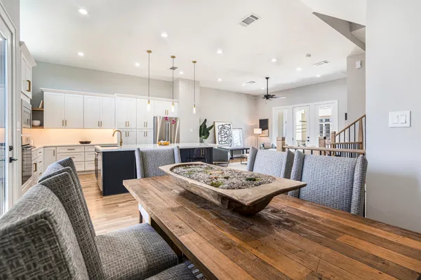 a living room with furniture kitchen view and a chandelier