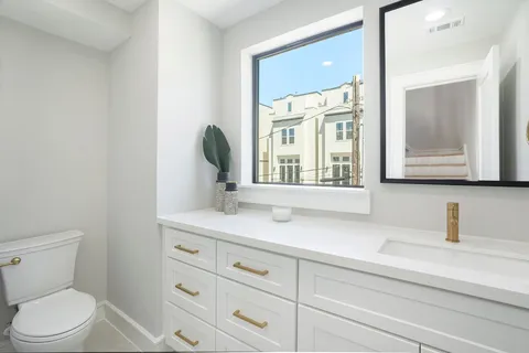 a bathroom with a sink a toilet and a mirror