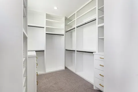 a view of walk in closet with empty racks