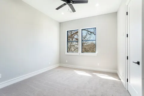 an empty room with a window and a ceiling fan