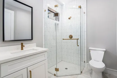 a bathroom with a shower a toilet and a sink