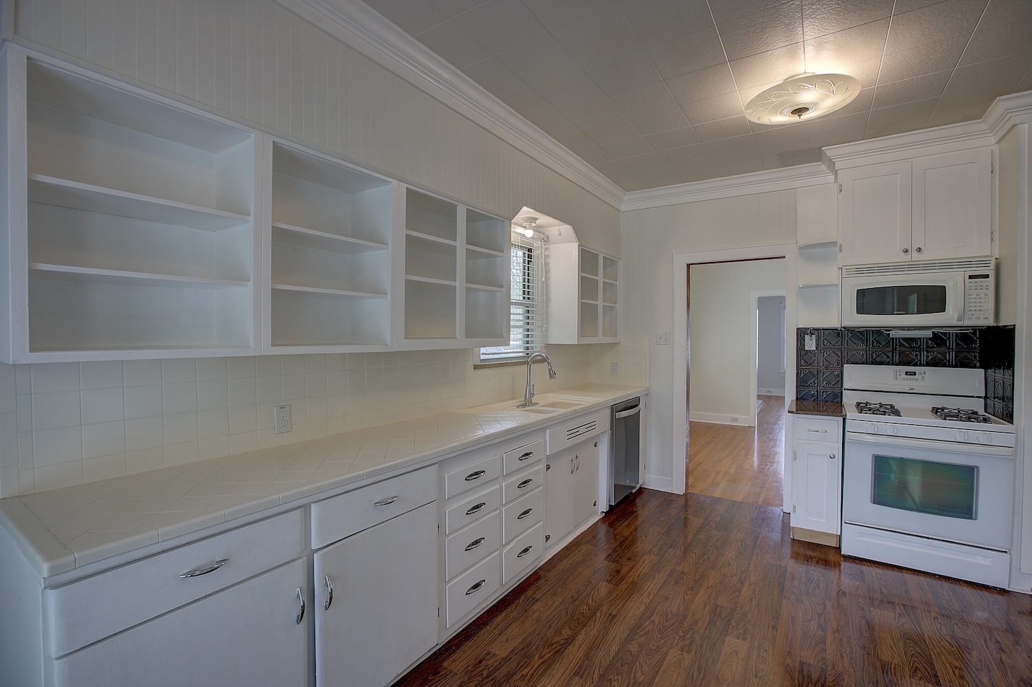1708 Olive Street Georgetown, TX 78626 - Photo 9 of 40 a kitchen with cabinets wooden floor and stainless steel appliances