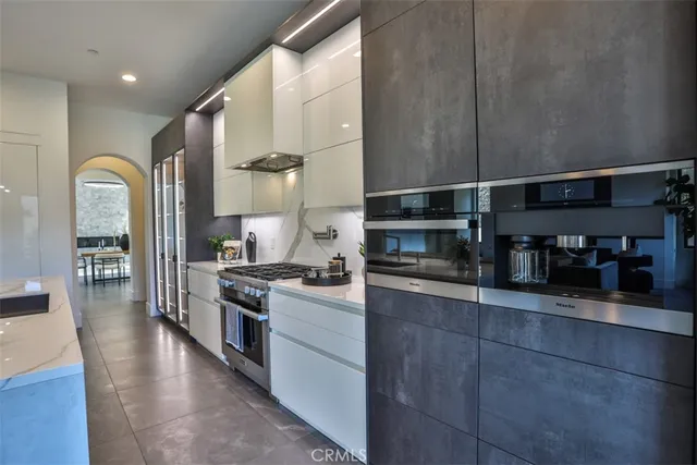 a kitchen with stainless steel appliances granite countertop a refrigerator a stove and a sink with wooden floor