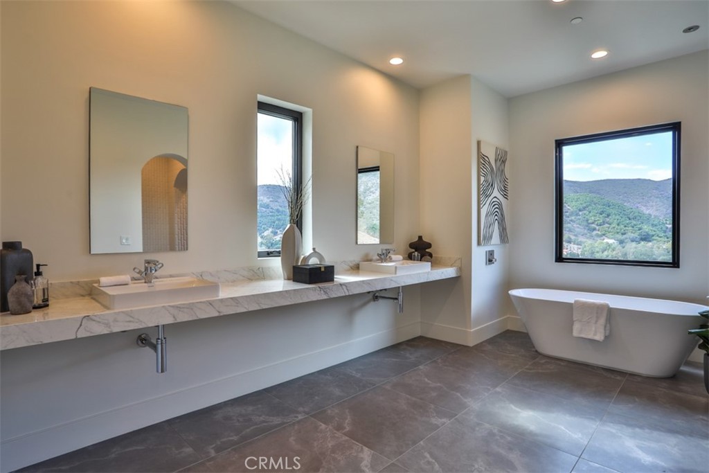 43698 De Luz Road Temecula, CA 92590 - Photo 34 of 60 a bathroom with a double vanity sink toilet and a large mirror