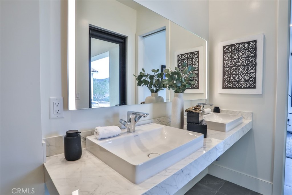 43698 De Luz Road Temecula, CA 92590 - Photo 44 of 60 a bathroom with a sink a toilet and mirror