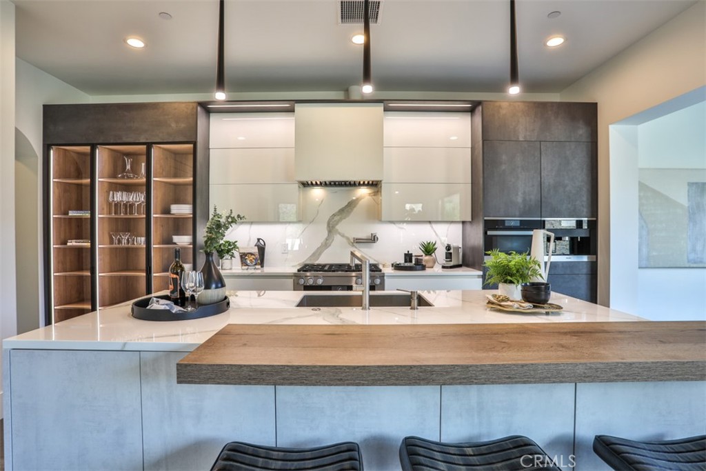43698 De Luz Road Temecula, CA 92590 - Photo 9 of 60 a kitchen with a refrigerator a stove and a wooden cabinets