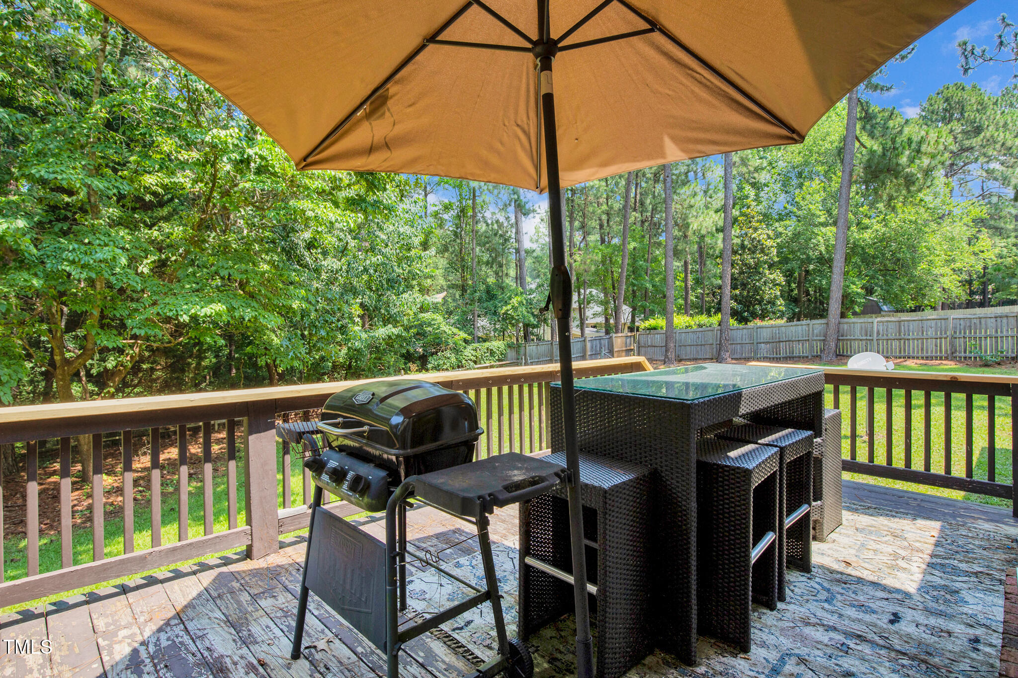7832 Shuttle Road Fayetteville, NC 28311 - Photo 29 of 35 a view of a deck with a table and chairs under an umbrella