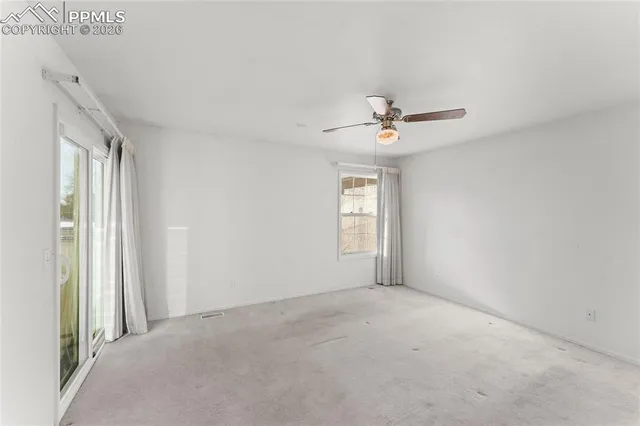 a view of empty room with ceiling fan
