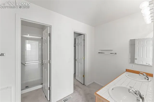 a bathroom with a granite countertop sink a toilet and shower