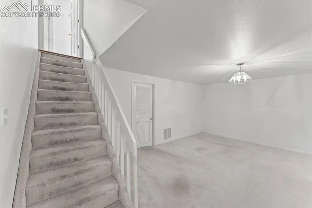 an empty room with windows and ceiling fan