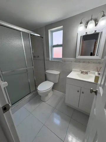 a bathroom with a sink a toilet a mirror and shower